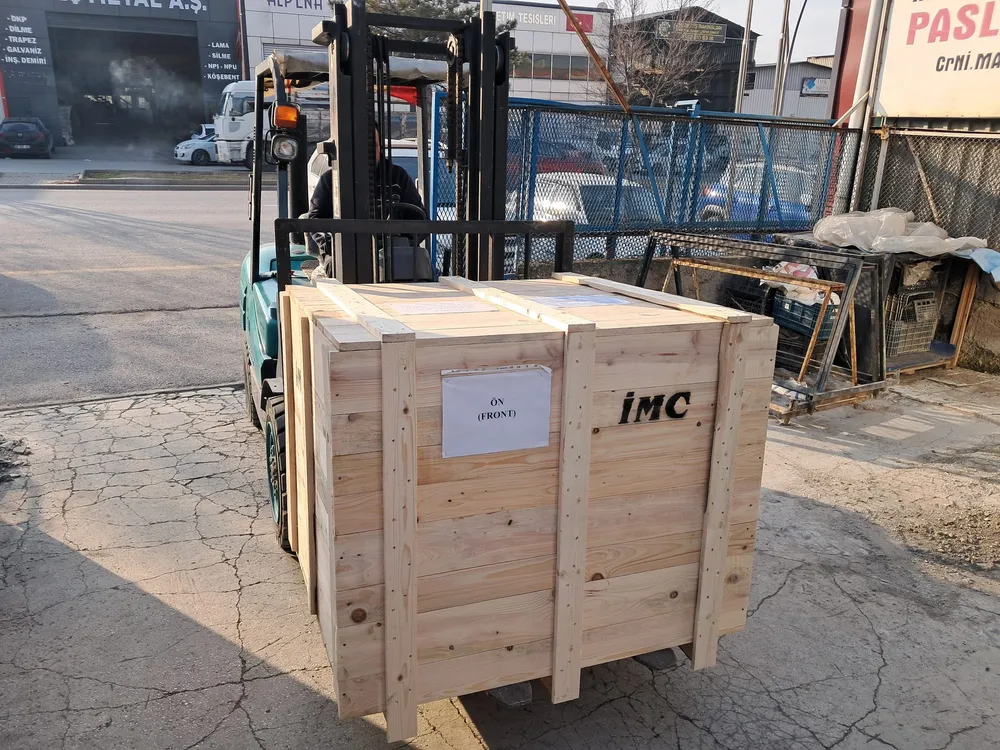 Almanya’ya gönderilmek üzere ahşap sandığa alınmış, IMC yazılı makine forkliftte